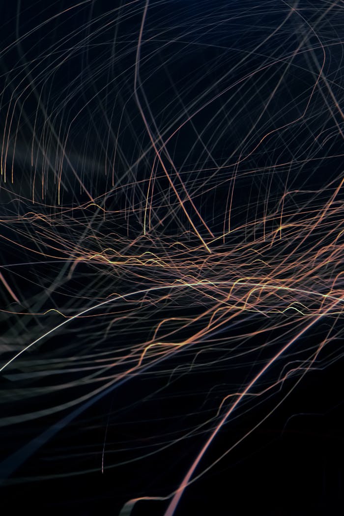 An artistic display of colorful light trails weaving across a dark backdrop, ideal for modern designs.